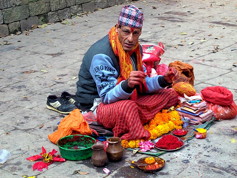 Uno dei tanti nepalesi che vende offerte propiziatorie e che applica la “tilaka”